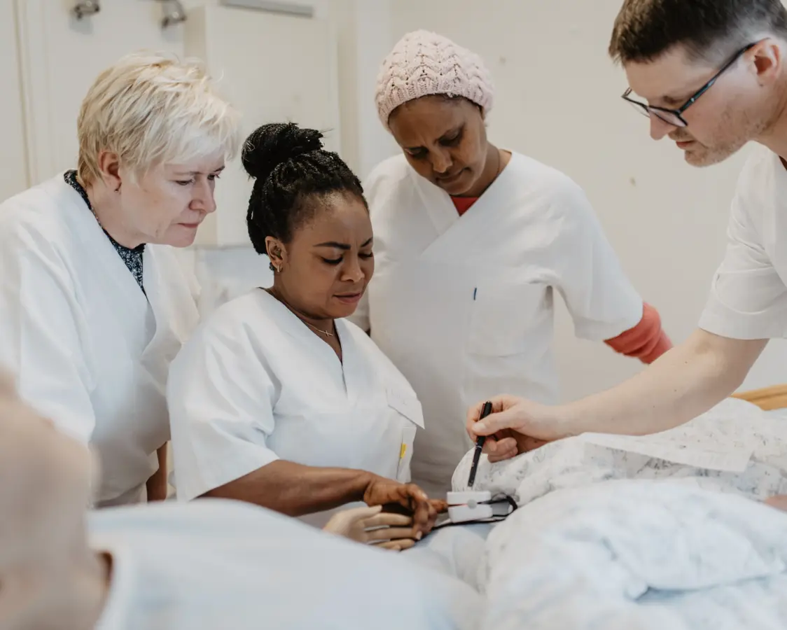 En dame underviser foran mange studenter