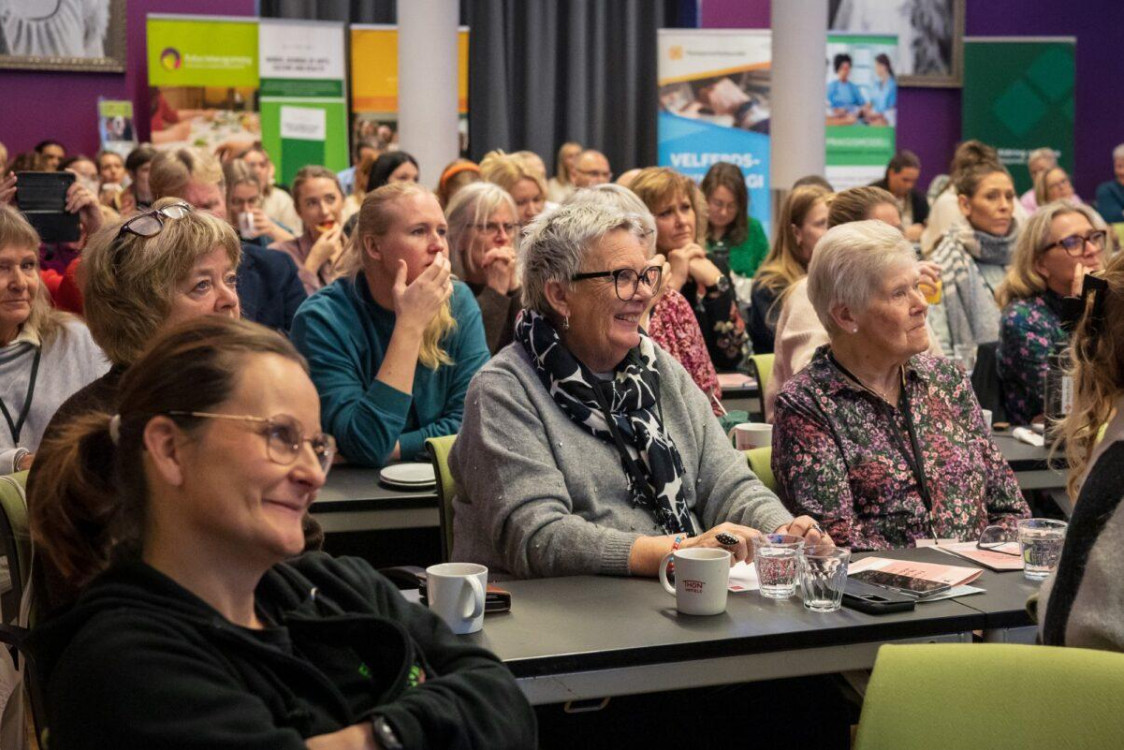 mange deltakere på konferansen om frivillighet smiler mens de lytter