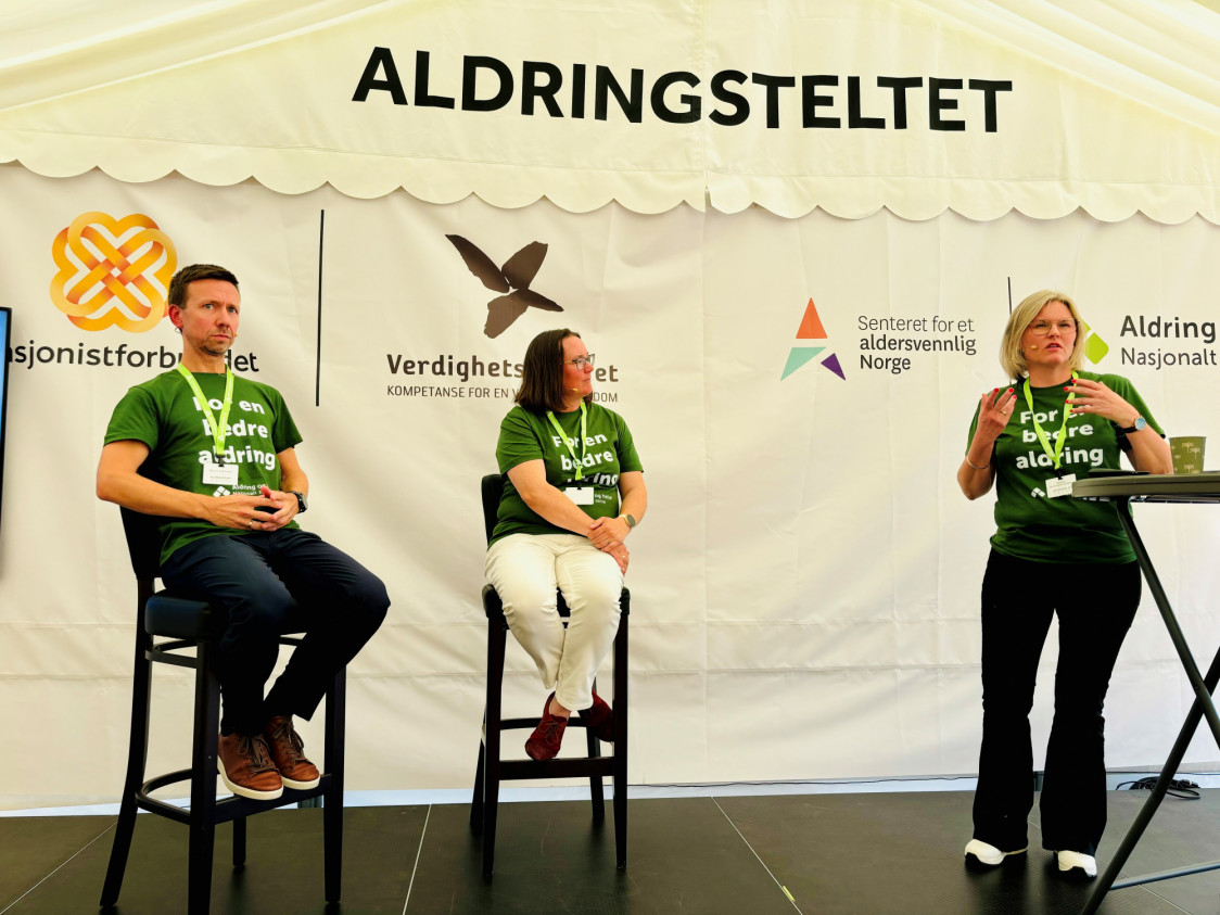 tre sitter på en scene og prater
