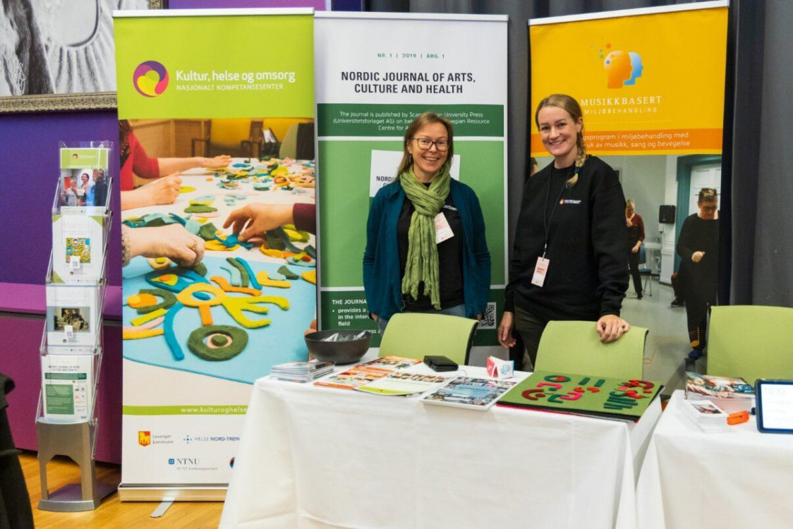 to smilende damer på stand under konferansen