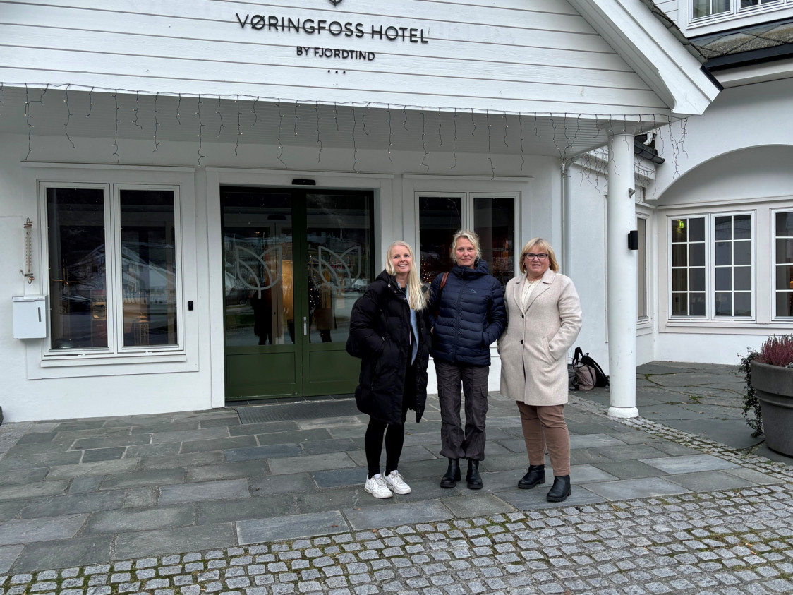 tre damer smiler utenfor et hotell
