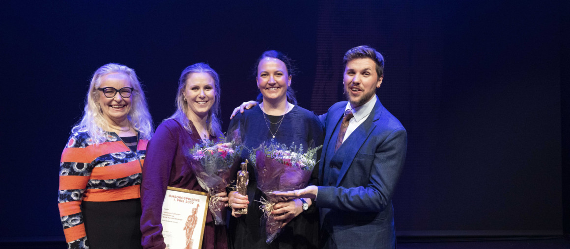 to kvinner får blomster og pris av mann og helsebyråd