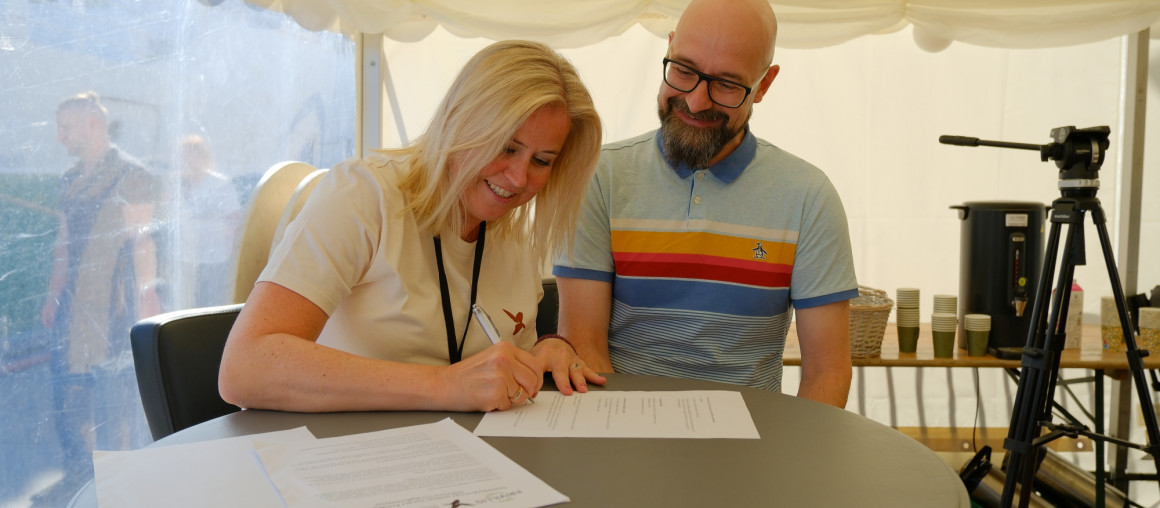 en mann og dame signerer en avtale om samarbeid
