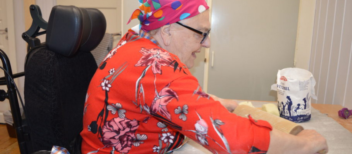 Eldre kvinne baker lefse.