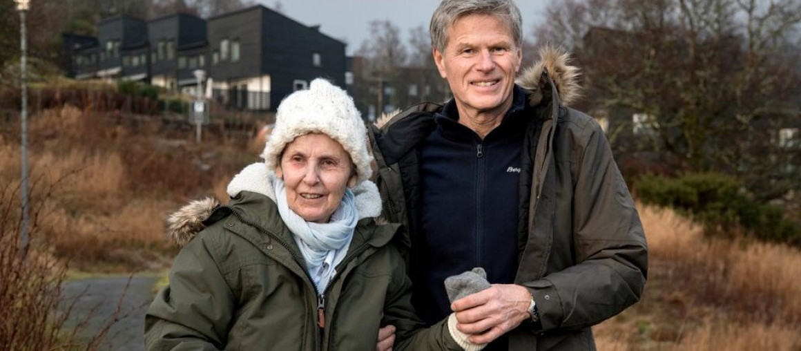 et ektepar sitter sammen i en sofa og smiler