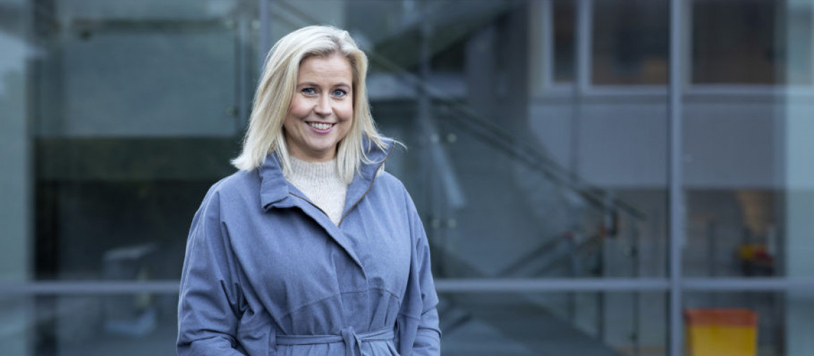 Kvinne med armene i jakkelommene