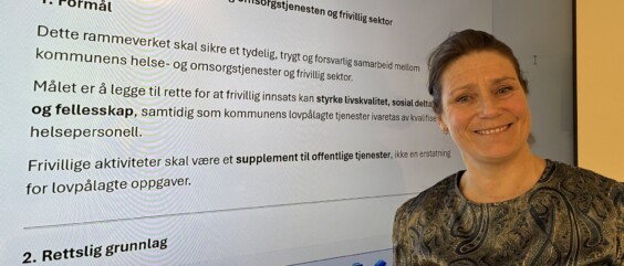 Frivillighetskoordinator foran skjerm med informasjon om rammeverk