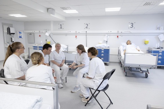 flere pleiere sitter sammen og diskuterer