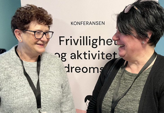 to damer smiler mot hverandre