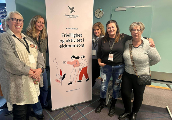 bilde av en gjeng damer stående ved en Verdighetsenter roll up