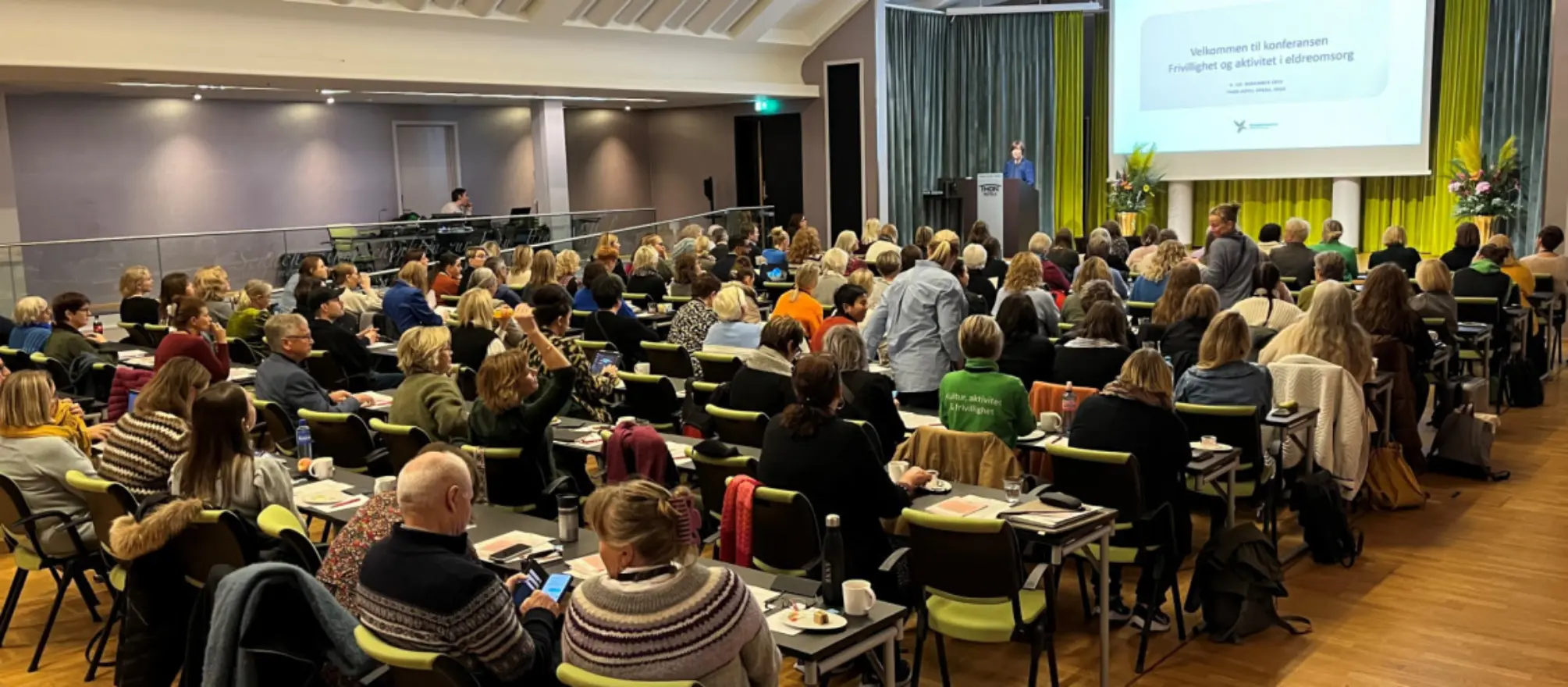 Konferansedeltakere følger med på foredrag