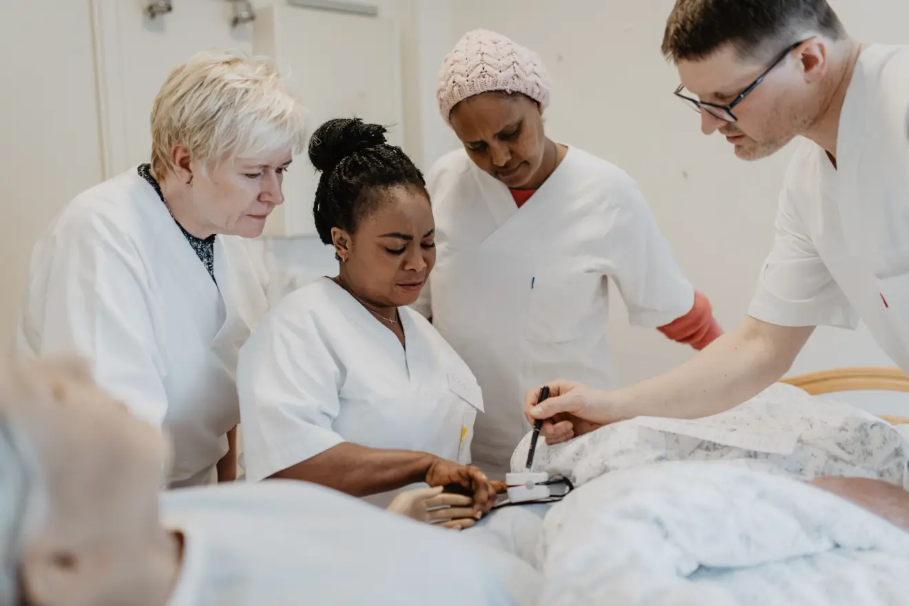 En dame underviser foran mange studenter